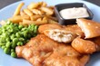 Tasty fish, chips, sauce and peas on table, closeup