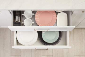 Poster - Clean plates, bowls and cutlery in drawers indoors, top view