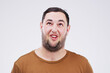 Man, funny face and open mouth in studio for comic, comedy and crazy or weird expression. Comedian, facial gesture and pout for joke, prank and laugh on isolated gray background with mockup space