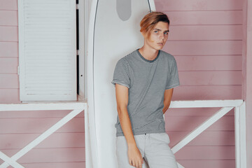 A young attractive guy is relaxing on the beach near a bungalow.