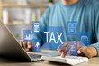 © GamePixel - Tax and Vat concept. Government, state taxes concept. Businesman using calculator and laptop to complete Individual income tax return form online for tax payment. Data analysis, financial research.