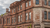 Fototapeta Natura - The facade of an ancient brick abandoned building.