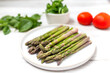 Asparagus on a plate on the table with tomato and salad. Healthy menu concept.  