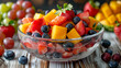 glass bowl with chopped fruits and berries in ice water on a wooden table on which there are also fruits and berries
