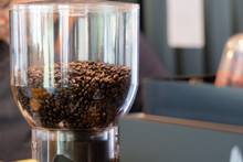 A Coffee Grinder With A Large Amount Of Coffee Beans Inside