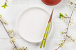Table adorned with cherry blossom branch and chopsticks, epitomizing Japanese food culture