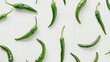 Several green chilis scattered loosely, their fresh and natural appearance contrasted sharply against a pure white backdrop