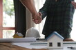 © Sutthicha - Engineer and contractor join hands after signing contract,They are having a modern building project together. successful cooperation team concept