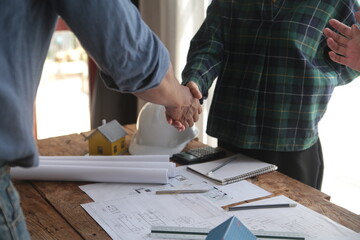 Wall Mural - Engineer and contractor join hands after signing contract,They are having a modern building project together. successful cooperation team concept