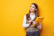 © Musarrof - Photo of smart woman dressed knitwear waistcoat hold copybook look at promo empty space write plan isolated on yellow color background