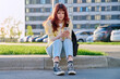 Young beautiful serious woman using smartphone, sitting on floor, urban style