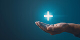 Fototapeta  - Close up of male hand holding glowing cross on dark background. Medicine and healthcare concept. 