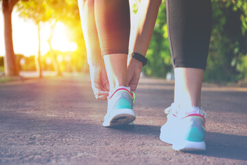 Wall Mural - runner woman tying up laces of shoes, getting ready to run for cardio and weight loss