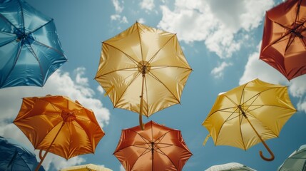 Poster -   A collection of vibrant umbrellas hovering above, against a backdrop of cloud-specked blue sky