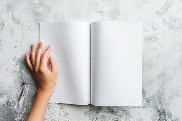 Hand touching a page of an open blank booklet