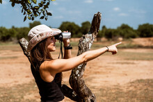 Woman Exploring Wildlife With Binoculars In Natural Setting