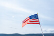 © ADDICTIVE STOCK - American flag waving against a clear blue sky