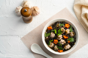 Wall Mural - Thai style Clear seaweed soup with carrot ,Minced Pork ball and glass noodle in white bowl.(Gaeng Jued ).Top view.