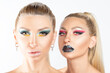 Fashion twins with a bright make-up posing in studio. Beauty, cosmetics and makeup concept.