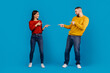 © Prostock-studio - A man and a woman standing facing each other, both pointing accusingly at each other with serious expressions. They seem to be engaged in a heated discussion or argument.