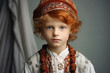 Portrait of a young boy with red hair wearing traditional clothes
