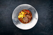 Traditional slow cooked German wagyu beef roulades with vegetable and gnocchi served in spicy red wine sauce as close-up in a Nordic design plate with copy space