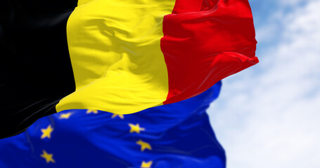 Belgium and European Union flags waving together on a clear day