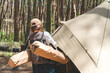 キャンプ場でコット・テーブルを運びテント設営をする女性キャンパー
