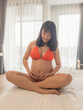 Asia sexy pregnant mother in red bikini in the bedroom