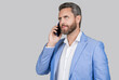 Businessman using phone. Man in jacket has phone conversation. Business communication. Casual man talking on phone in studio. Man talking on phone isolated on grey. Copy space
