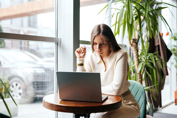 Poster - woman sitting at table using laptop computer