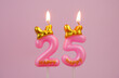 Pink birthday candle with bow and word happy burning on pink background., number 25.