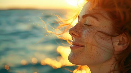 A woman is standing on the beach, feeling the wind in her hair and the warmth of the sun on her closed eyes. Her happy gesture reflects the joy of being in the moment AIG50