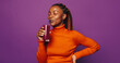 Cheerful woman holding a colorful smoothie, standing on a vibrant purple background