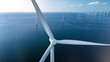 Towering windmill turbines intricately placed in the vast ocean expanse of the Netherlands Flevoland region, harnessing the power of the wind to generate clean energy