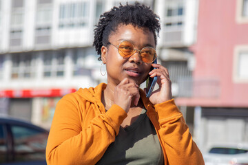 Wall Mural - african american woman talking on the phone thoughtfully on the street