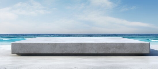 Sticker - Front view of a grungy grey concrete stone platform podium for cosmetics or products set against a white beach sand background with copy space image