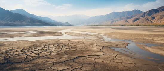 Canvas Print - Aerial view of a desiccated alluvial lake with a scenic backdrop of mountains Copy space image available