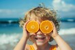 Happy child boy on the beach, laughing covering his eyes with orange halves, summer vacation concept