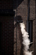Steam coming out of a central heating flue on a house wall in South Korea.
