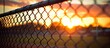 At sunset a copy space image captures the tranquil beauty of a deserted baseball diamond during the off season as seen through a fence