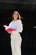 © MM - Business Woman in a white shirt and white pants Stands with a folder in her hands and checks documents