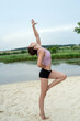 Young caucasian woman in sport wear doing yoga relax exercise near lake