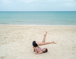 Young caucasian female trainer practicing yoga at sea beach. Sport for weight loss exercise