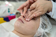 beautician doing relaxing facial massage to young caucasian woman at spa salon