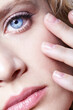 Closeup portrait of young female face. Woman with natural nude makeup. Hand near face