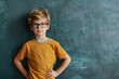Smart Child in Cute Pose near Chalkboard. Caucasian Boy Showing Intelligence in Classroom