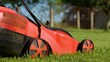 Side view of lawn-mower machine cutting grass outdoors in garden. Close up of an electric lawn mower mows lawn in the backyard. Garden care. Gardening concept, nature and landscape