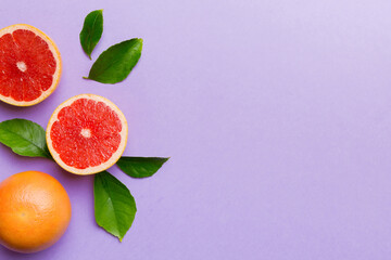 Wall Mural - fresh Fruit grapefruit with Juicy grapefruit slices on colored background. Top view. Copy Space. creative summer concept. Half of citrus in minimal flat lay with copy space