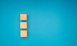 Three wooden cubes are on a blue background.